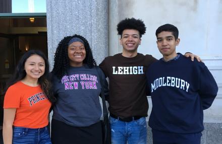 Four students from the Blue Owl Gives program wearing their college sweatshirts